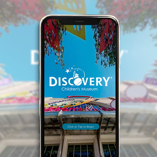 photo of a mobile phone with a simulated image of a view of the Discovery Children's museum building close up