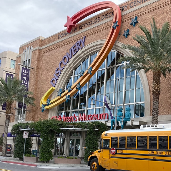 the entrance to the Discovery Children's Museum with a very large semicircular window, a display featuring a colorful shooting star, and a school bus