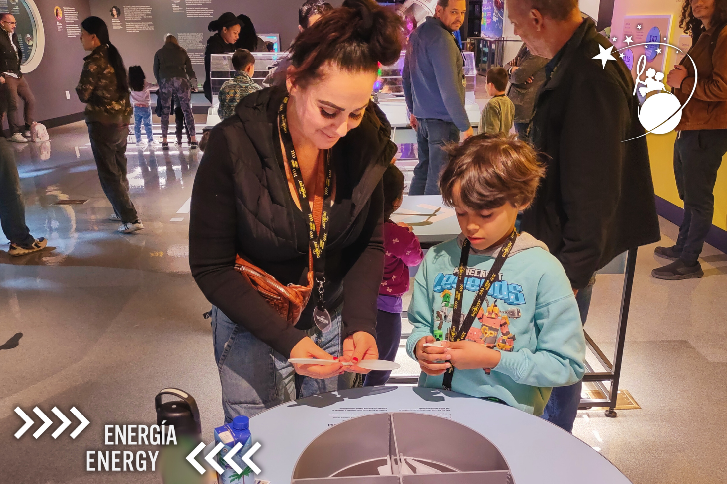 ディスカバリー子供博物館の展示で、プラスチック製の小さなプロペラを手にする親子。