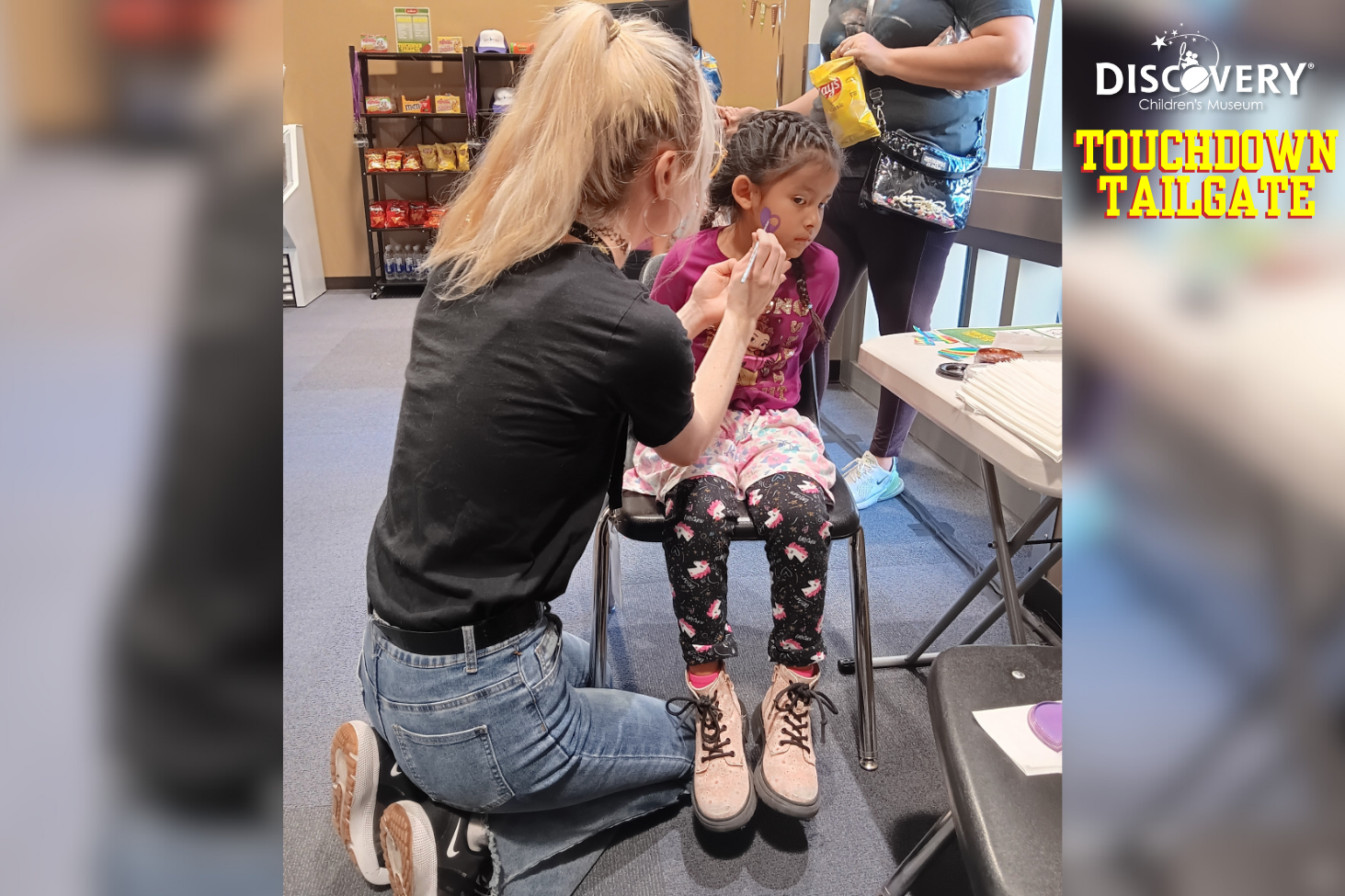 a face painter painting a heart on a girl's face at the Discovery Children's Museum