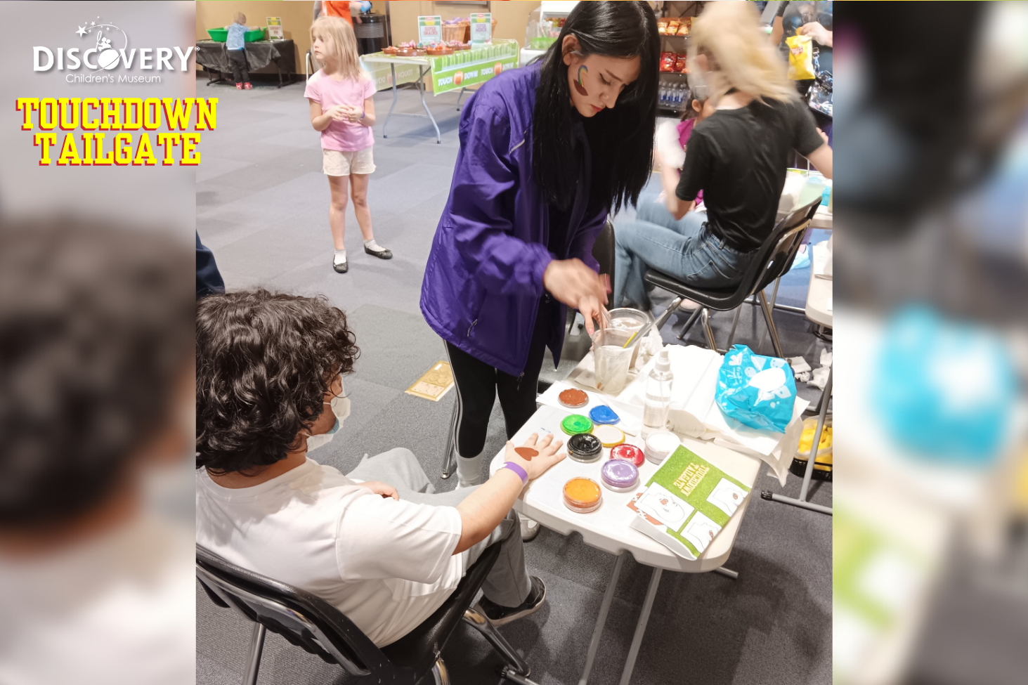 Un pintor de caras pinta en la mano de un niño en el Discovery Children&#039;s Museum