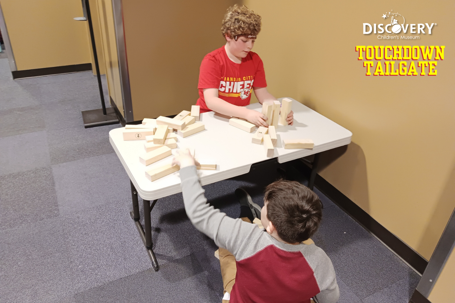 两名儿童在发现儿童博物馆的一张桌子前竖起木制积木